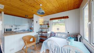 a kitchen and dining room with a table and chairs at F67 Ischia, Riviere Towans in Hayle
