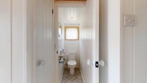 a white bathroom with a toilet and a sink at F67 Ischia, Riviere Towans in Hayle +12 photos