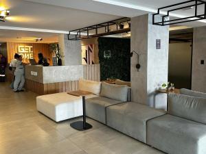 a lobby with a couch and a table and a bar at Get One - João Pessoa in João Pessoa +64 photos