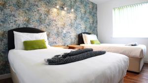a bedroom with two beds and a wall at Tigh Na Sith in Aultbea
