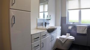 a white bathroom with a sink and a toilet at Tigh Na Sith in Aultbea +38 photos