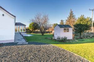 a house with a small shed next to a yard at Tigh Na Sith in Aultbea