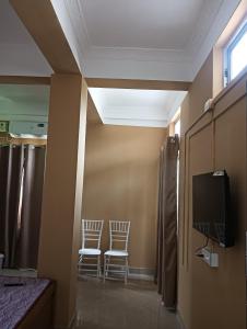 two chairs in a room with a tv and a wall at Swagat Lodge in Chāngsāri