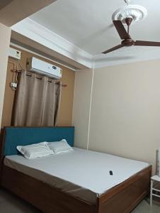a bedroom with a bed with a ceiling fan at Swagat Lodge in Chāngsāri