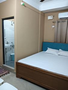 a bedroom with a bed and a bathroom with a shower at Swagat Lodge in Chāngsāri