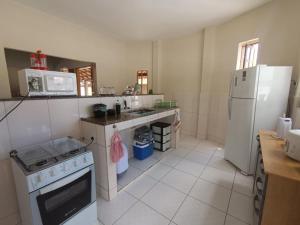 a kitchen with a stove and a refrigerator at Suíte Externa Casal in Rio das Ostras