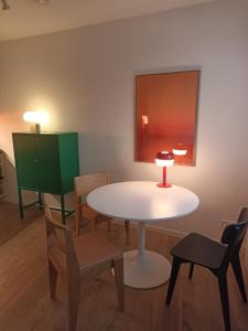 a room with a white table and chairs and a painting at Casa Stetten in Lörrach