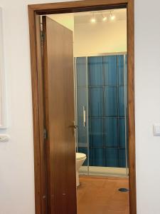 a bathroom with a toilet and a wooden door at Casa do Profeta in Porto Santo +34 photos