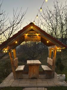 a wooden structure with a bench and a sign at Cabana Dintre Fagi in Poiana Mărului