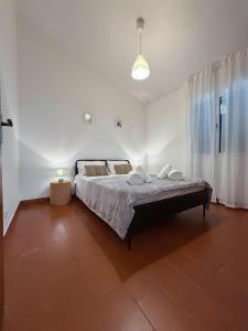 a bedroom with a bed in a white room at Casa do Profeta in Porto Santo