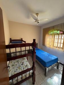 two bunk beds in a room with a ceiling fan at CasaPraiaSol1 in Rio das Ostras +63 photos