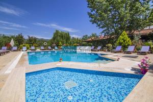 a swimming pool in a resort with chairs at Kaya Koy Deluxe Villas Fethiye in Fethiye