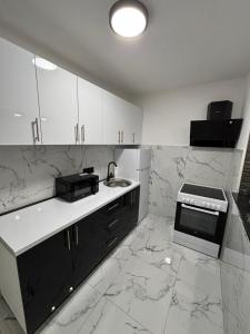 a kitchen with white marble counters and a sink at Apartman Miljanic in Vlasenica +4 photos