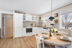a kitchen with a wooden table and white cabinets at TV1705-Bindslev-Nordkapvej-4 in Tversted +10 photos