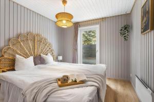 a bedroom with a large bed with a wooden headboard at TV1705-Bindslev-Nordkapvej-4 in Tversted