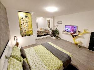 a bedroom with a bed and a tv on the wall at The Kiss Apartment in Timişoara