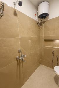 a bathroom with a shower with a toilet at Haraa Suites Tiruvannamalai in Tiruvannāmalai