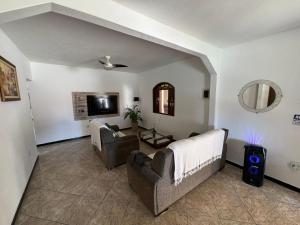 a living room with two couches and a tv at CasaPraiaSol1 in Rio das Ostras
