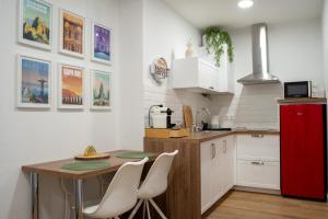 a kitchen with a wooden table and a red refrigerator at Judería Suite Jaén in Jaén