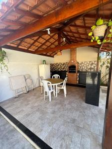 a patio with a table and chairs under a roof at CasaPraiaSol1 in Rio das Ostras