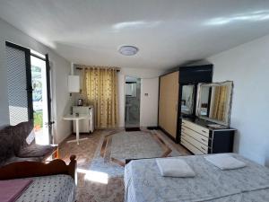 a bedroom with a bed and a tv and a couch at Hillside Haven in Durrës