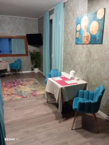 a dining room with a table and blue chairs at BF SUITE Foresteria Bellusci in Rho