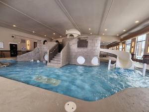 a indoor pool with a water slide in a building at The Wisconsin Hotel & Conference Center in Wisconsin Dells