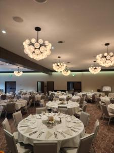 a banquet room with white tables and chairs and chandeliers at The Wisconsin Hotel & Conference Center in Wisconsin Dells