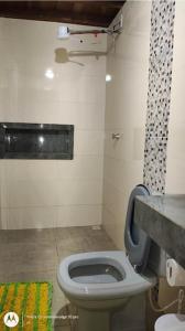 a bathroom with a toilet with a counter and a sink at Casa aconchegante em Sinop in Sinop +4 photos