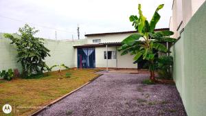 a white house with a blue door in a yard at Casa aconchegante em Sinop in Sinop