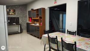 a kitchen and dining room with a table and a refrigerator at Casa aconchegante em Sinop in Sinop