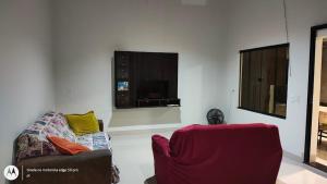 a living room with a couch and a chair at Casa aconchegante em Sinop in Sinop