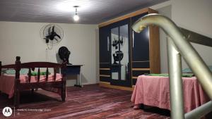 a bedroom with a bed and a table and a fan at Casa aconchegante em Sinop in Sinop
