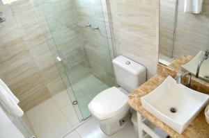 a bathroom with a shower and a toilet and a sink at Hospedaria Canto do Morro in Bombinhas