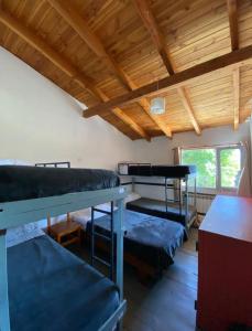 a room with three bunk beds and a table at Hostel Punto Patagónico Bariloche in San Carlos de Bariloche