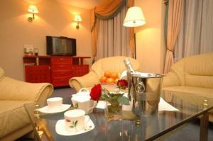 a living room with a coffee table with flowers on it at Hotel Kongresowy in Kielce
