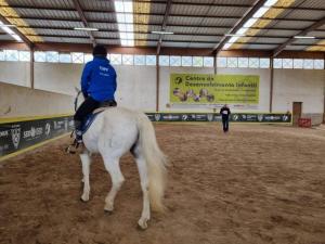 a man riding a horse in an arena at Casa de Campo Patio do Avô - Varanda do Pátio in Routar