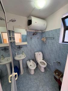 a bathroom with two sinks and a toilet and a shower at Hillside Haven in Durrës +21 photos