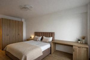 a bedroom with a bed and a wooden desk at Cozy space in Iaşi