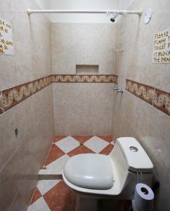 uma casa de banho com WC e piso em azulejo em Arcadia Hostel Medellin em Medellín