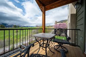 a table and a chair on a porch with a view at Snowcrest C304Ski Getaway Hot Tub & Theater Room in Eden