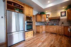 a kitchen with wooden cabinets and a stainless steel refrigerator at Snowcrest C304Ski Getaway Hot Tub & Theater Room in Eden