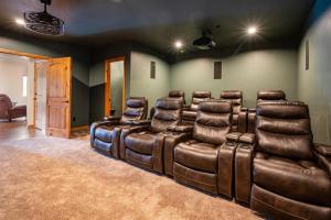 a theater room with a leather couch and chairs at Snowcrest C304Ski Getaway Hot Tub & Theater Room in Eden