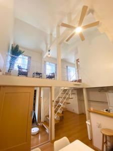a room with a staircase and a ceiling fan at AJITO Hostel 別館 in Shingū