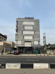 a building on a street with cars parked in front of it at The Hive Apartments - The Forge Unit in Lagos