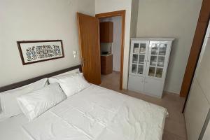 a bedroom with a white bed and a door at Villa Maty in Karianí