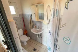 a small bathroom with a toilet and a sink at Villa Maty in Karianí