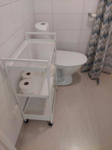 a bathroom with a toilet and a shelf with toilet paper at Enecopia Bed & Breakfast in Enköping +21 photos
