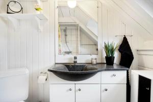 a bathroom with a black sink in a attic at 2289-Ringkobing-Nordso-Ferievej-21 in Klegod +32 photos