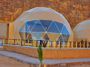 a building in a desert with a glass dome at Wadi rum Rozana camp in Wadi Rum